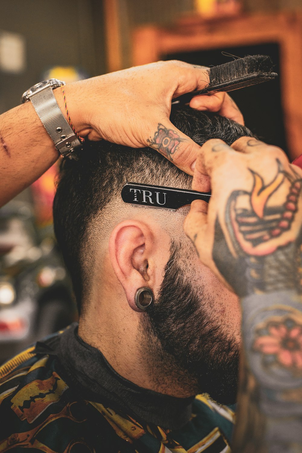 Barber detailing a client's hairline with a razor